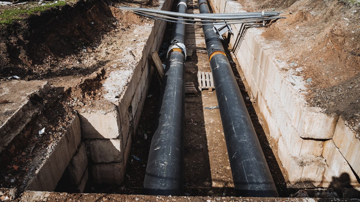 Metal pipes being laid in an open trench